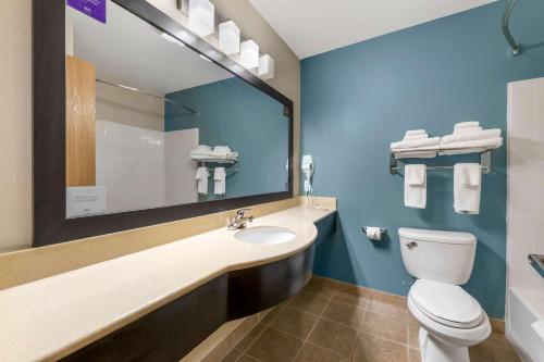 a bathroom with a toilet and a sink and a mirror at Sleep Inn & Suites Hays I-70 in Hays