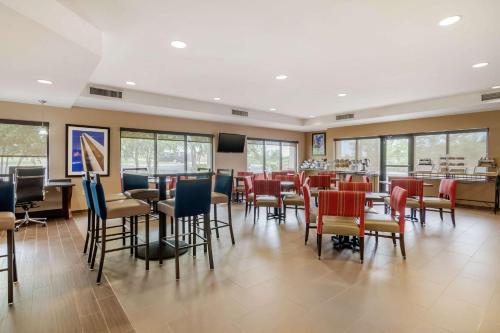 a restaurant with chairs and tables and a bar at Comfort Suites Speedway - Kansas City in Kansas City