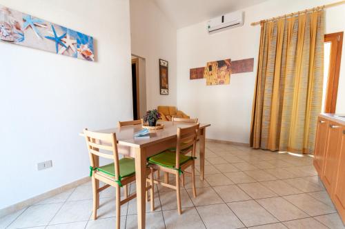 une salle à manger avec une table et des chaises en bois dans l'établissement Appartamento Fabio Caletta sul mare, à La Caletta