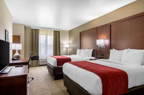 a hotel room with two beds and a desk at Comfort Inn & Suites Shawnee - Kansas City in Shawnee