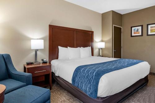 a hotel room with a bed and a blue chair at Comfort Inn & Suites Junction City - near Fort Riley in Junction City