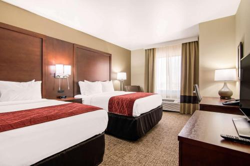 a hotel room with two beds and a desk at Comfort Inn & Suites - Independence in Independence