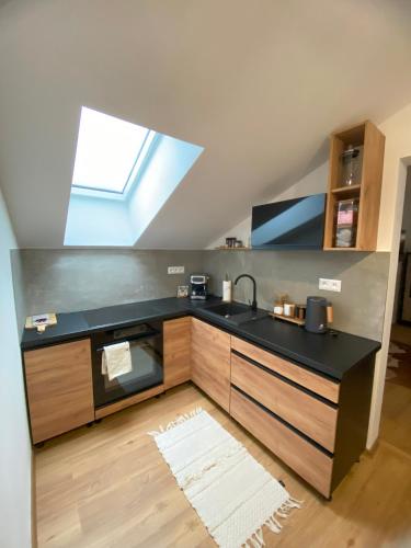 a kitchen with a sink and a skylight at Penzion a restaurace Staré Časy in Horní Bečva