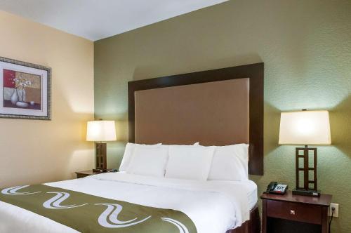 a hotel room with a large bed with two lamps at Quality Inn & Suites Slidell in Slidell