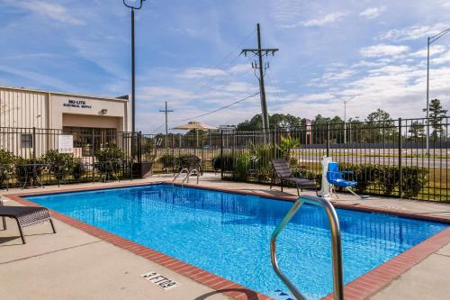a swimming pool with two chairs next to a building at Quality Inn & Suites Slidell in Slidell