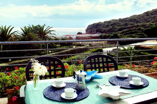 a blue table with plates and cups on a balcony at Camping Village Baia Azzurra in Castiglione della Pescaia
