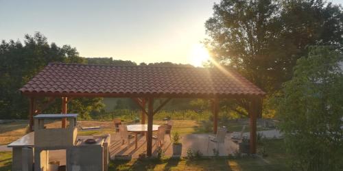 a wooden gazebo with a picnic table in a yard at La belle campagne in Granges-dʼAns