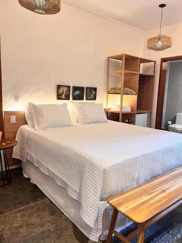 a bedroom with a large white bed and a table at Nazareth Cânion in Buriti dos Montes