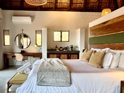 a bedroom with a large white bed and a desk at 57 Waterberg in Welgevonden Game Reserve
