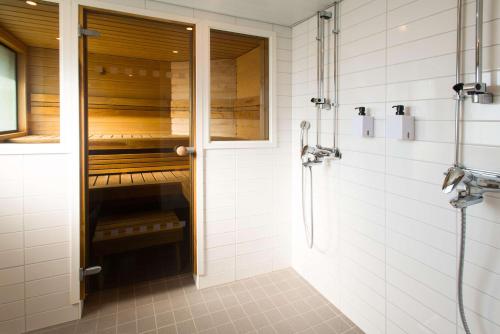a bathroom with a walk in shower next to a glass door at Scandic Kemi in Kemi