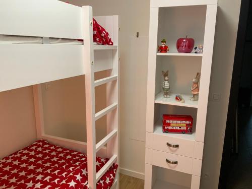 a bedroom with a bunk bed with white shelves at La madeleine in De Panne