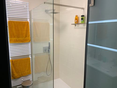 a shower stall with orange towels in a bathroom at La madeleine in De Panne