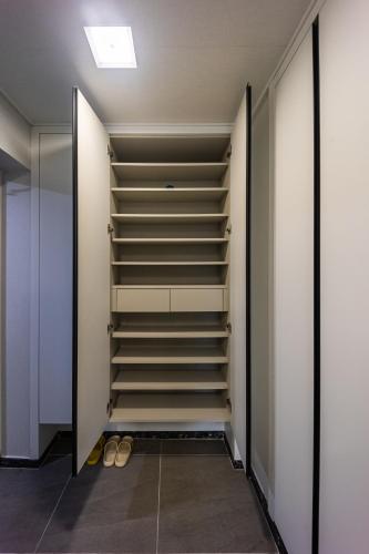 a walk in closet with stairs and shoes at Gwangalli #Modern #Korea in Busan