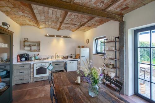 a kitchen with a wooden table and a refrigerator at Scheune Zauchwitz in Beelitz