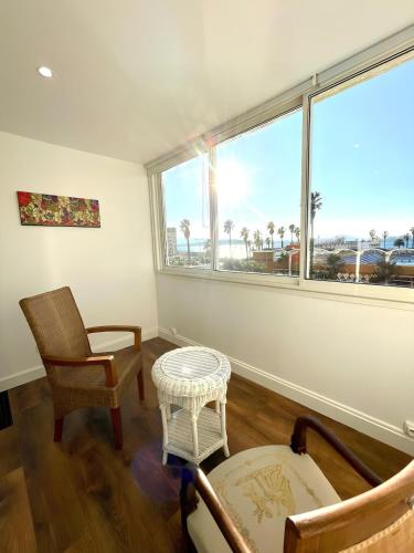 un salon avec deux chaises et une grande fenêtre dans l'établissement Le Navigateur - Wifi and 1 private parking space, à Toulon