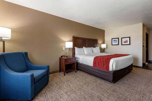 a hotel room with a bed and a blue chair at Comfort Inn & Suites Goodland in Goodland