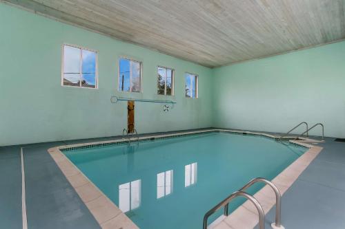 a large swimming pool in a room with windows at Rodeway Inn & Suites Hershey Chocolate Avenue in Hershey