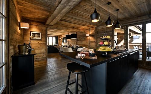 - une cuisine avec un îlot noir dans la chambre dans l'établissement Les Chalets D'Anthouard, à Crest-Voland