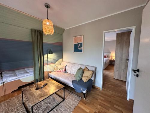 a living room with a couch and a bed at Sky & Sand - Endless Sea I Hochwertige, stilvolle Wohnungen, Strandnah, Boxspringbett, mit Garten in Sankt Peter-Ording