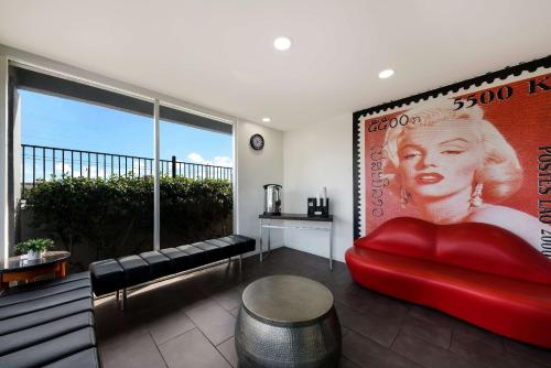a living room with a red couch and a large window at Rodeway Inn South San Francisco Airport in South San Francisco