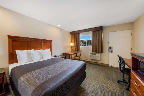 a hotel room with a bed and a desk at Rodeway Inn South San Francisco Airport in South San Francisco