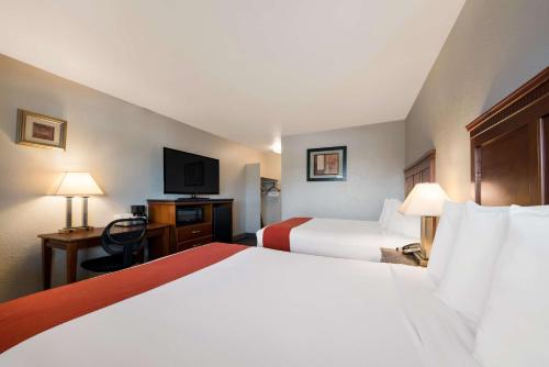 a hotel room with two beds and a television at Rodeway Inn South San Francisco Airport in South San Francisco