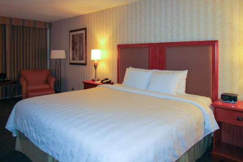 a hotel room with a large bed and a chair at Radisson Hotel Lenexa Overland Park in Lenexa