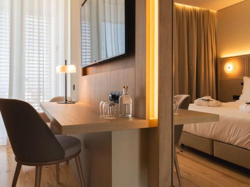a hotel room with a desk and a bed at Mercure Ponta Delgada Azores in Ponta Delgada