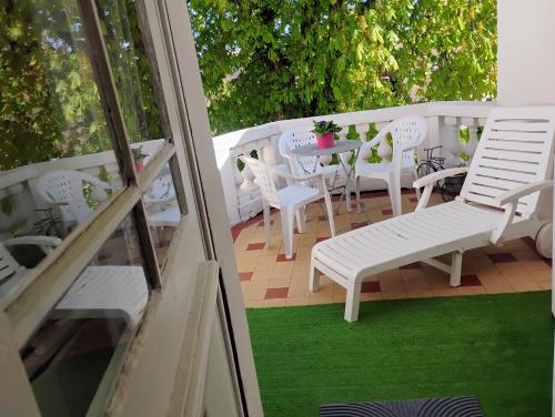 une terrasse avec des chaises blanches, une table, une table et des chaises dans l'établissement Gîte Le Marronnier - au calme - parking & terrasse - près de Colmar et Riquewihr - route des vins, à Châtenois