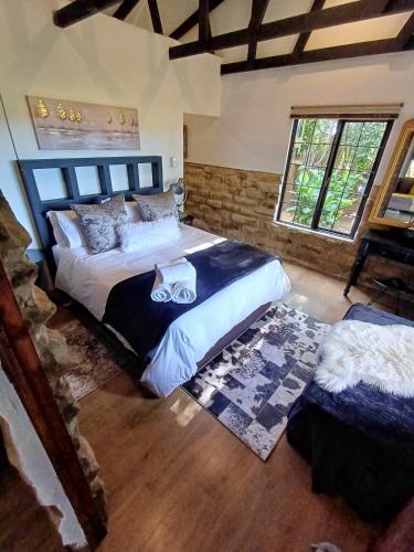 a bedroom with a large bed and a window at Affi lande Boetiek guestfarm in Fouriesburg