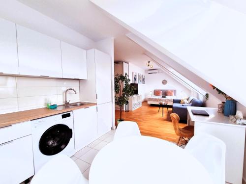 a kitchen with white cabinets and a living room at Bucharest Central EE Apartment in Bucharest