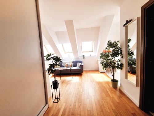 an attic living room with a couch and plants at Bucharest Central EE Apartment in Bucharest