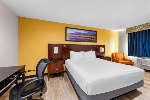 a hotel room with a bed and a desk and chair at Quality Inn San Diego South - Chula Vista in Chula Vista