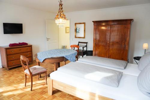 a bedroom with two beds and a table and a desk at Kielmeyerhaus in Esslingen