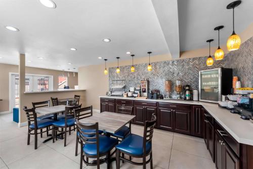 a kitchen with a dining area with tables and chairs at Quality Inn San Diego South - Chula Vista in Chula Vista