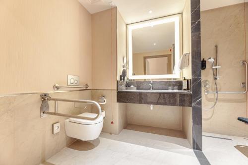 a bathroom with a toilet and a sink and a mirror at Tbilisi Philharmonic Hotel by Mercure in Tbilisi City