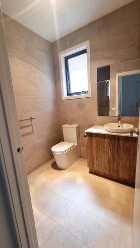 a bathroom with a toilet and a sink and a window at Cozy Room with Private Bathroom in Wheelers Hill