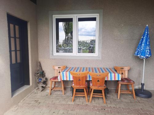 a table with four chairs and a window at Apartma Grlica in Selnica ob Muri