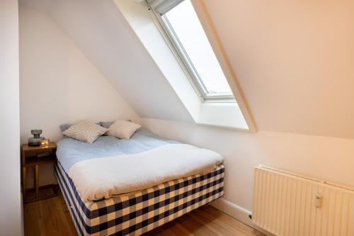 a small bedroom with a bed with a skylight at Penthouse in the heart of Copenhagen in Copenhagen
