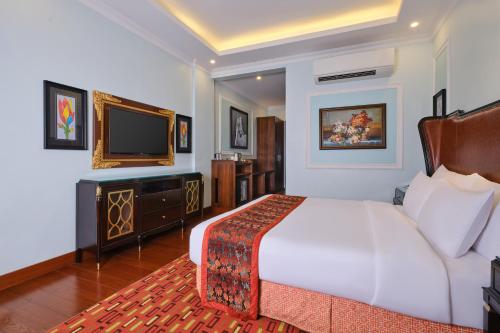 a hotel room with a bed and a television at Mayfair Spa Resort & Casino in Gangtok