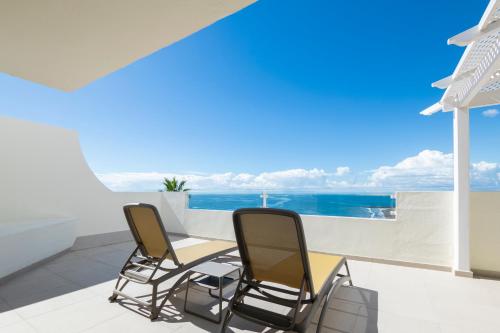 two chairs and a table on a balcony with the ocean at Abora Interclub Atlantic by Lopesan Hotels in San Agustin