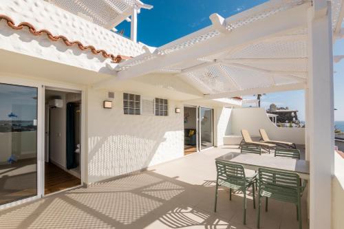 a patio with a table and chairs on a house at Abora Interclub Atlantic by Lopesan Hotels in San Agustin