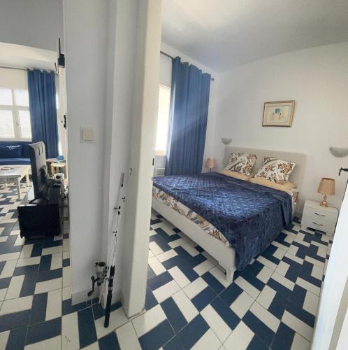 a bedroom with a bed with a blue comforter at Bel appartement au coeur du Port El Kantaoui in Port El Kantaoui