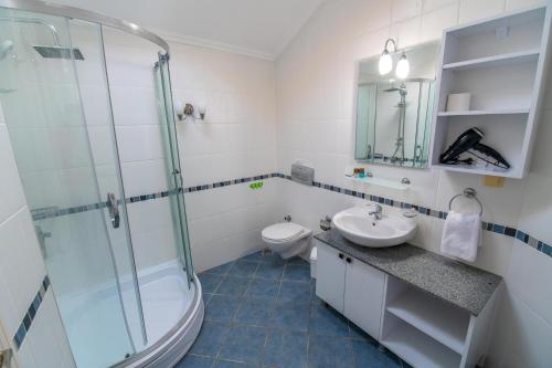 ein Badezimmer mit Dusche, Waschbecken und Toilette in der Unterkunft Sunset Beach Club Aqualettings Poseidon 7 in Fethiye