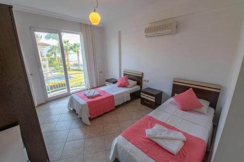 ein Hotelzimmer mit zwei Betten und einem Fenster in der Unterkunft Sunset Beach Club Aqualettings Poseidon 7 in Fethiye