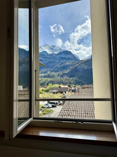 a window with a view of a mountain at Spacious, stylish & central apartment, Great excursions in surrounding area in Meiringen