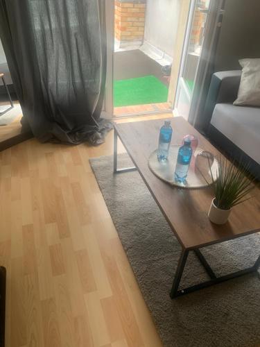 - un salon avec une table et 2 bouteilles dans l'établissement Chambre d'hôte chez Kahi, à Brunoy