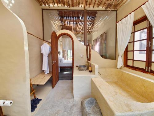 a bathroom with a tub and a large mirror at Red Sands Mui Ne in Phan Thiet