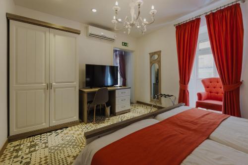 a bedroom with a bed and a flat screen tv at Jean de Valette Boutique Living in Valletta