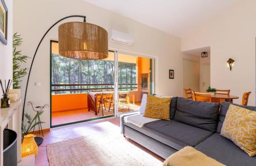 a living room with a couch and a dining room at Aroeira - Sea & Golf Apartment in Aroeira